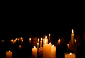 Community members holding candles during a vigil for peace and civility.
