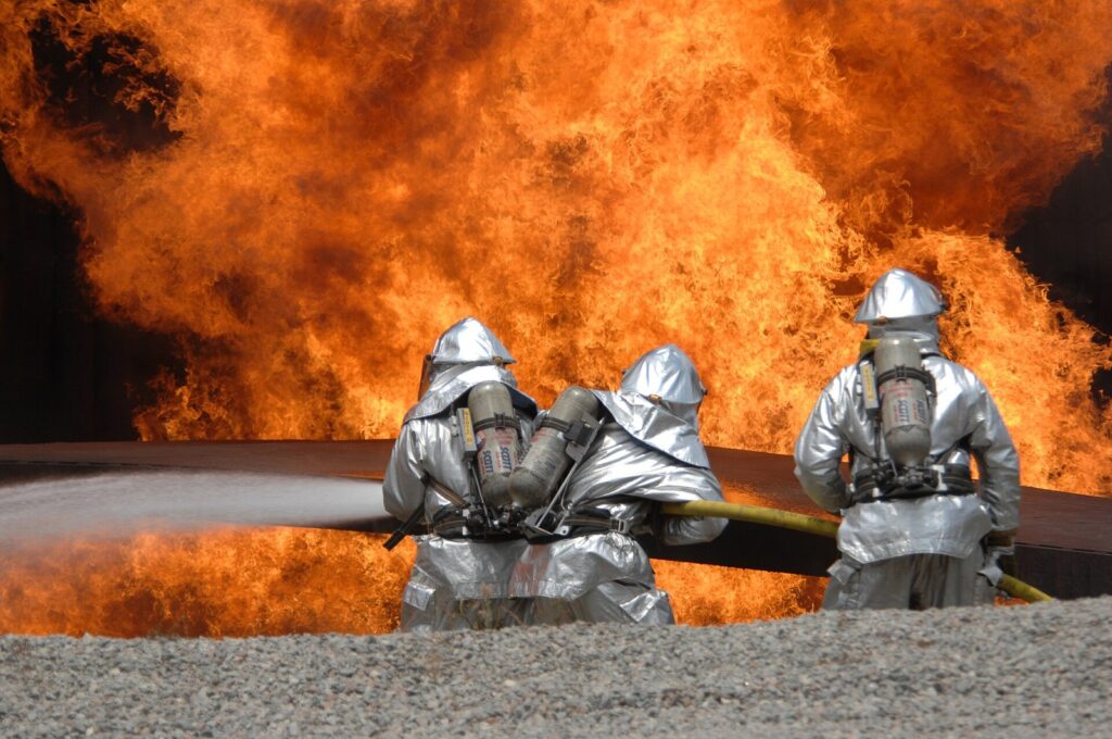 Firefighters in front of flames