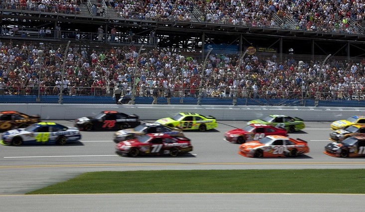 NASCAR stock cars racing past a full grandstand